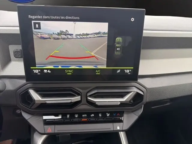 Vue intérieure du tableau de bord du Dacia Bigster gris foncé, écran tactile affichant la caméra de recul avec guidage dynamique.