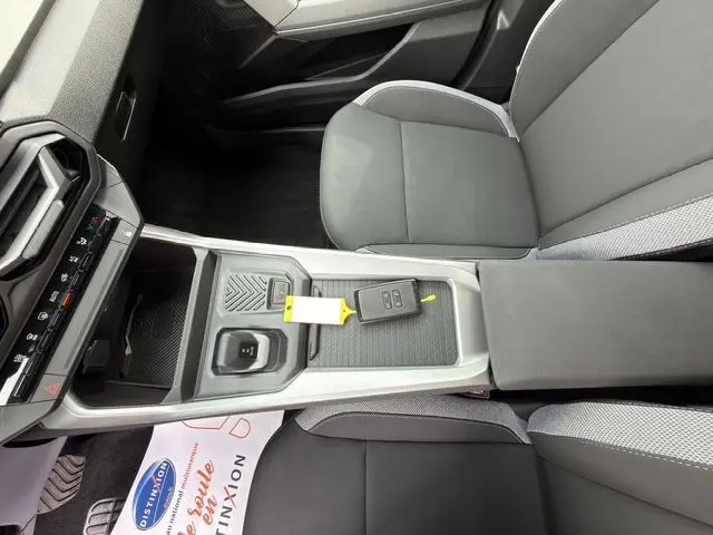 Vue intérieure du centre console gris clair du Dacia Bigster Extreme Hybrid 2026 avec clé et sièges tissu gris foncé.