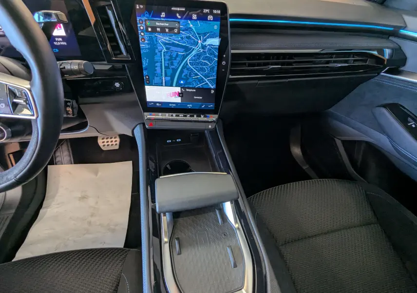 Vue intérieure du tableau de bord et console centrale du Renault Espace VI E-Tech noir étoile avec écran tactile vertical et sièges en tissu noir.