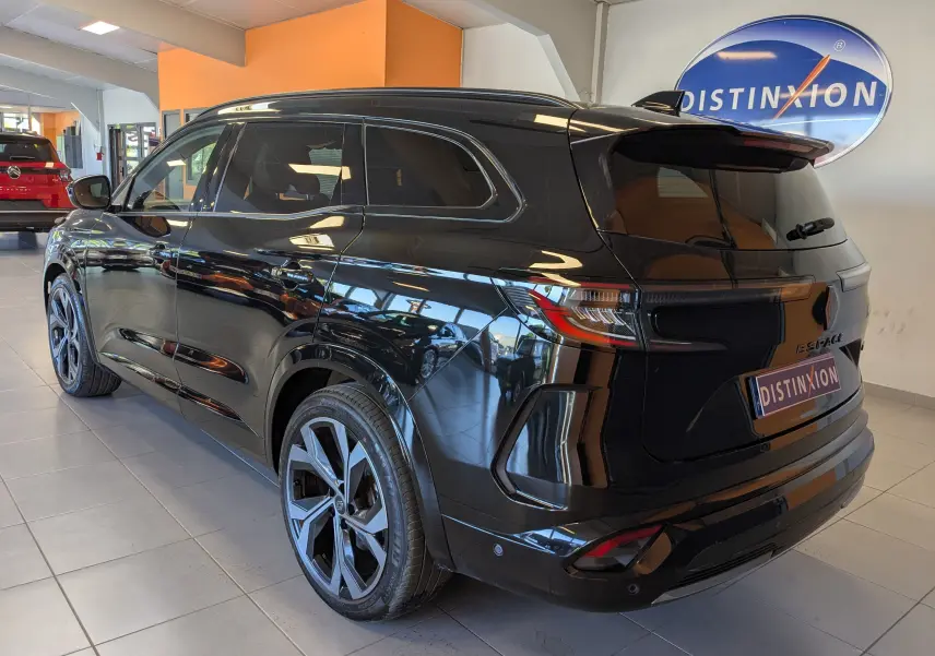 Vue 3/4 arrière droite du Renault Espace VI noir étoile avec jantes alliage 20 pouces Daytona en showroom.