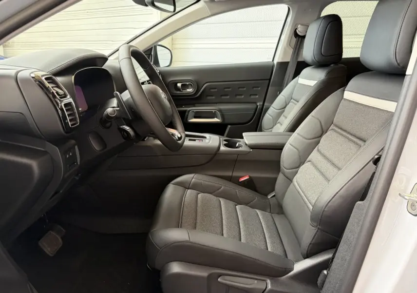 Intérieur avant droit du Citroën C5 Aircross blanc 2025, sièges cuir et tissu gris, tableau de bord moderne avec écran tactile.
