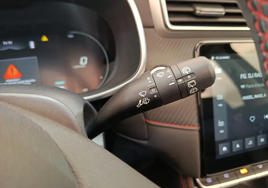 Gros plan sur la commande des essuie-glaces du MG Motor ZS Luxury noir, avec tableau de bord et écran tactile visibles.