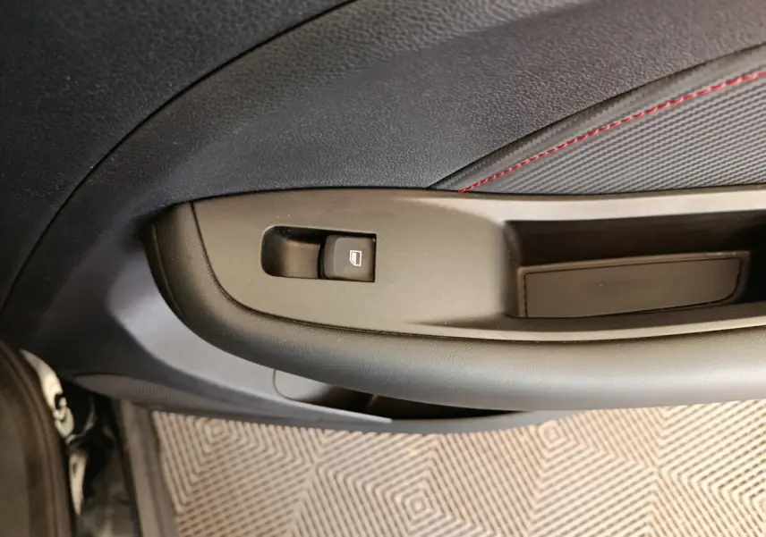 Détail de la commande de lève-vitre sur la porte côté conducteur d’un MG Motor ZS Luxury noir 2024.
