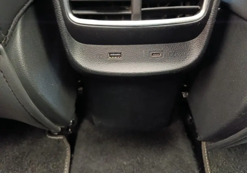 Vue rapprochée de la console arrière noire du MG ZS Luxury 2024 avec prises USB et aérateurs visibles.