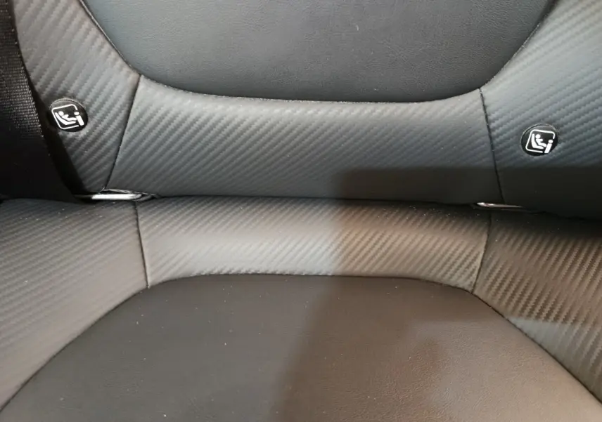 Détail de la banquette arrière noire avec tissu effet carbone et logos Isofix du MG Motor ZS Luxury 2024.