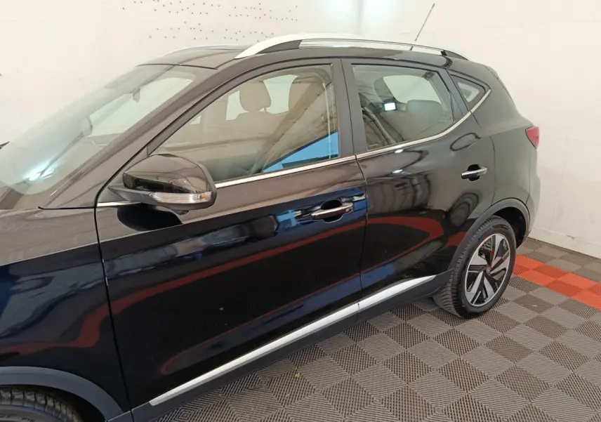 Vue latérale côté gauche du MG MOTOR ZS Luxury 70kWh noir, mettant en valeur les jantes et les rétroviseurs avec clignotants intégrés.