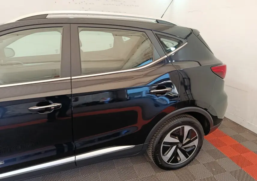 Vue latérale côté droit du MG ZS Luxury 70kWh noir, mettant en valeur les jantes et la ligne de toit chromée.