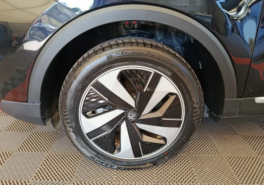 Gros plan sur la roue avant droite noire du MG ZS Luxury 70kWh 2024 avec jante bicolore au design géométrique.