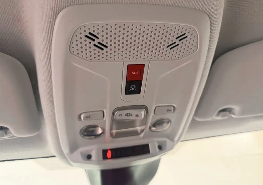 Vue en contre-plongée du plafonnier blanc avec bouton SOS et commandes d’éclairage du Peugeot 208 2025.