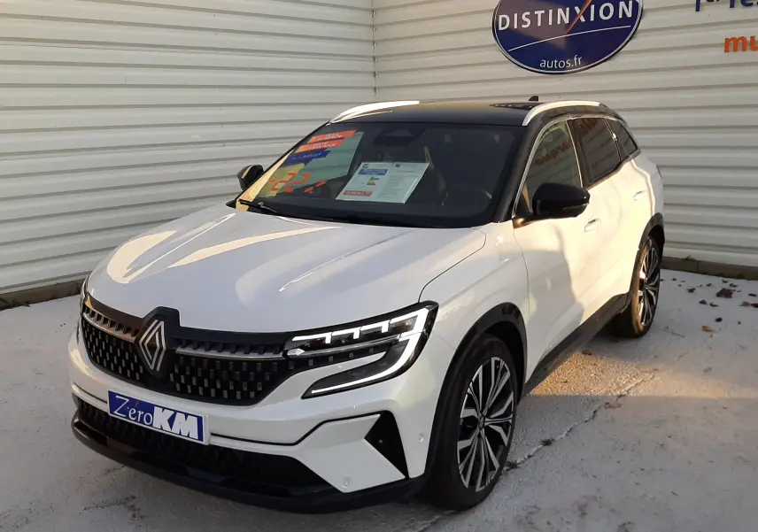 Renault Austral E-Tech Full Hybrid 200 Iconic blanc nacré avec toit noir, vue 3/4 avant droit, calandre et phares LED distinctifs.