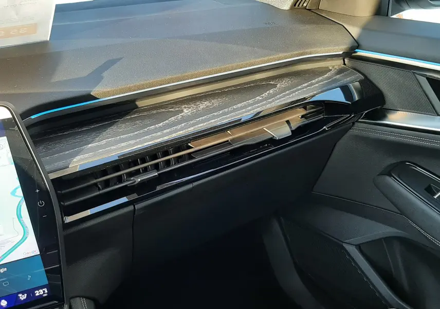 Vue intérieure côté passager du tableau de bord noir brillant et bois clair du Renault Austral E-Tech 2025.