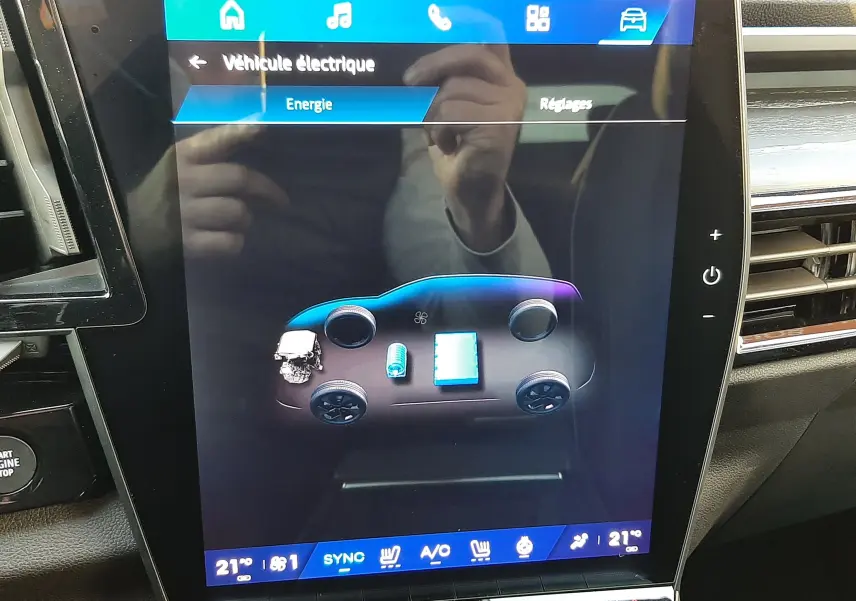 Écran tactile intérieur du Renault Austral E-Tech Hybrid 2025 montrant l'énergie électrique et la température à 21°C.