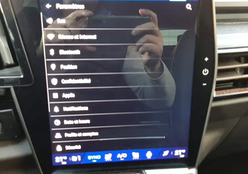 Écran tactile central du Renault Austral 2025, intérieur noir, affichant le menu des paramètres connectés.