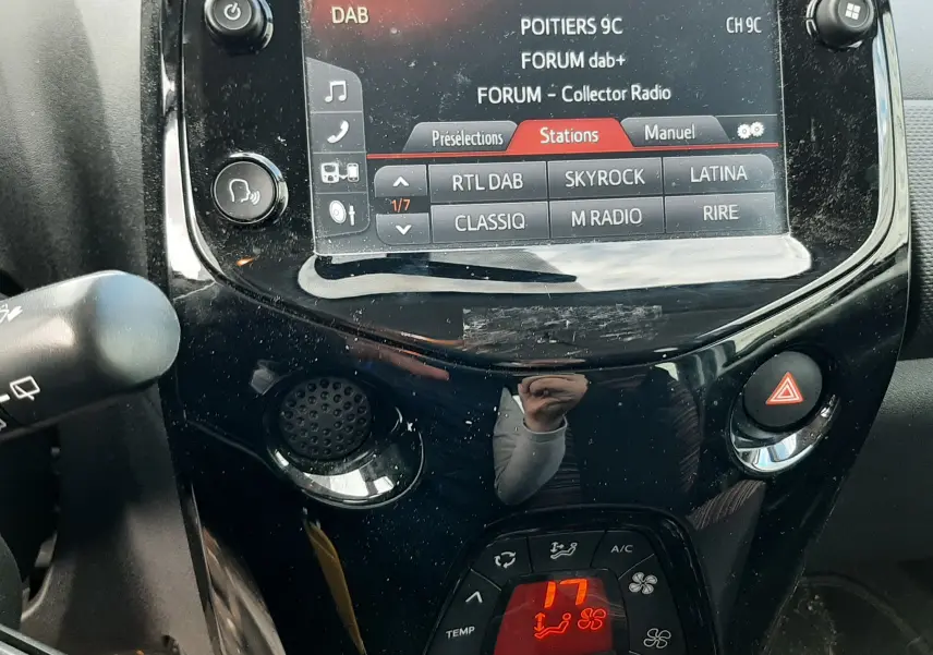 Gros plan sur la console centrale noire du Citroën C1 2021, avec écran tactile et commandes climatisation digitales.