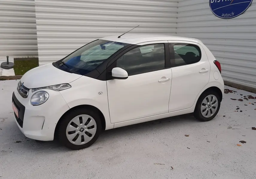 Citroën C1 blanc vue de profil côté gauche, compacte 5 portes avec jantes acier et rétroviseurs blancs.