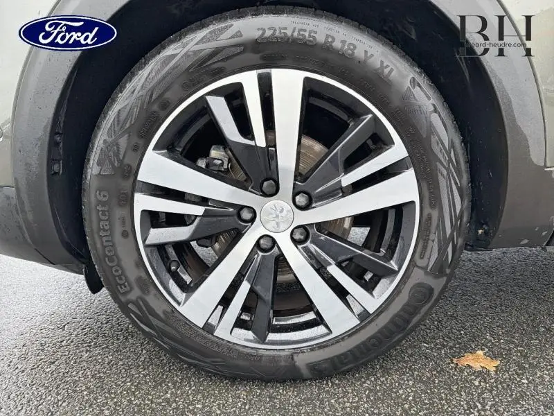 Gros plan sur la jante alliage bicolore et le pneu Continental d’un Peugeot 5008 gris Amazonite, roue arrière droite.