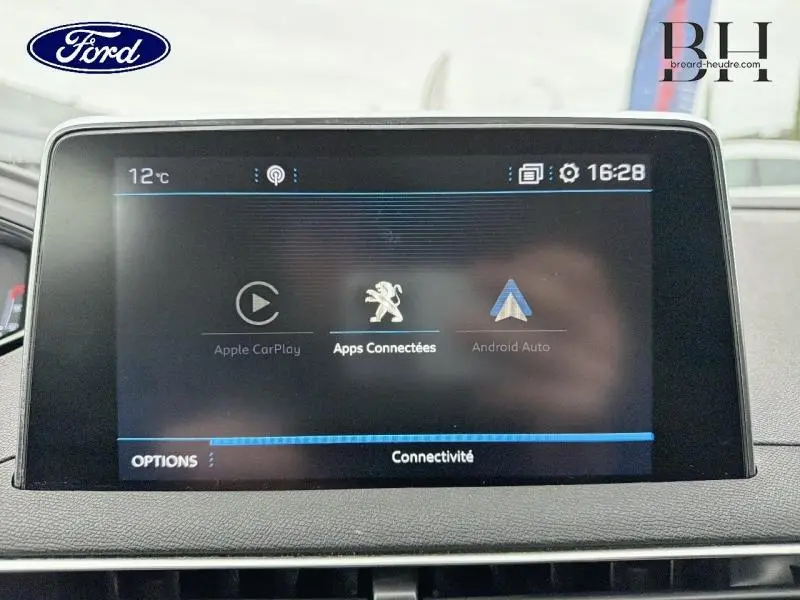 Écran tactile central du tableau de bord avec interface connectée, vue frontale intérieure sans visibilité du véhicule extérieur.