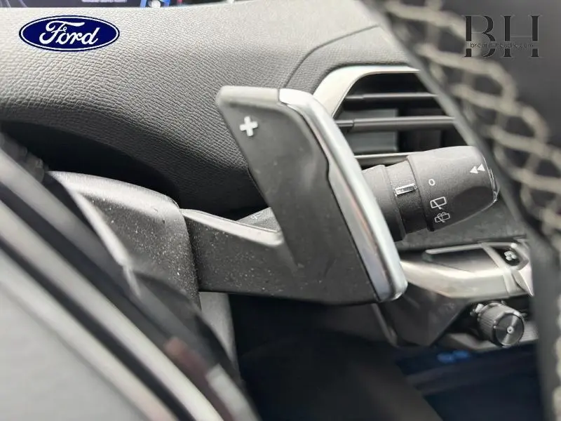 Gros plan sur la palette de changement de vitesse droite en plastique noir avec insert chromé dans l'habitacle du Peugeot 5008 gris Amazonite.