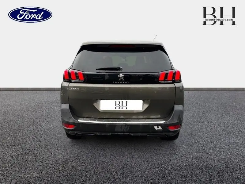 Vue arrière d'un Peugeot 5008 gris Amazonite avec feux LED caractéristiques et hayon noir brillant.