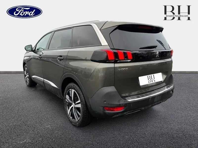 Peugeot 5008 gris Amazonite vue 3/4 arrière droit, feux arrière LED et jantes alliage visibles.