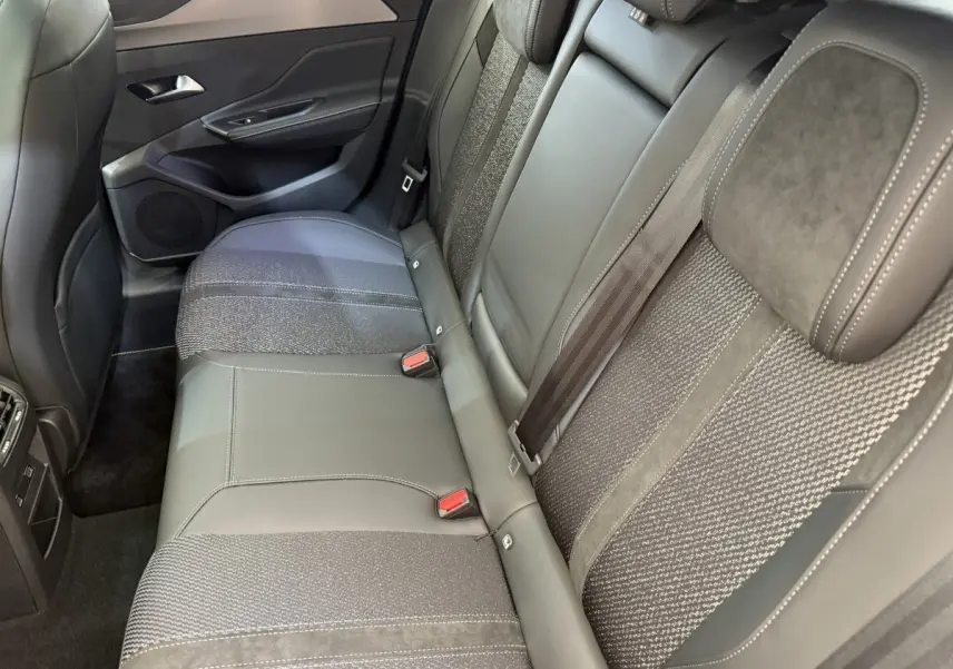 Vue intérieure côté droit des sièges arrière en cuir et tissu gris foncé de la Peugeot 308 Hybrid 136 e-DCS6 GT 2024.