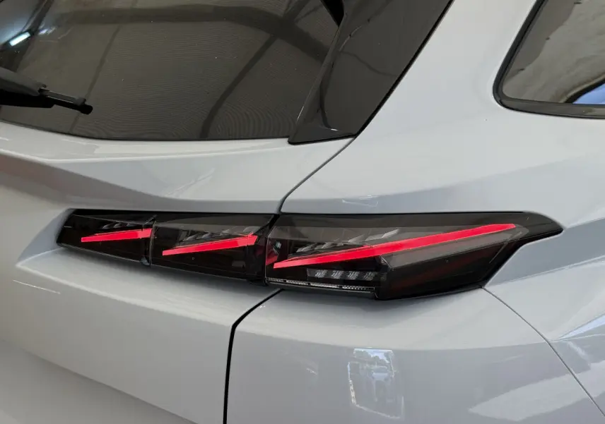 Gros plan sur le feu arrière droit rouge de la Peugeot 308 Hybrid 136 e-DCS6 GT blanche, vue arrière côté droit.