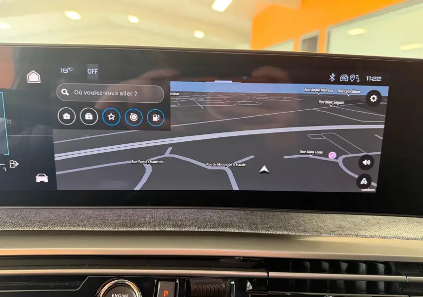 Vue rapprochée de l’écran GPS HD 21’’ du Peugeot 5008 Hybrid 145 GT avec tableau de bord tissu gris.