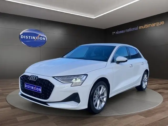 Audi A3 30 TFSI blanc vue 3/4 avant droit, calandre noire hexagonale et jantes argentées en showroom
