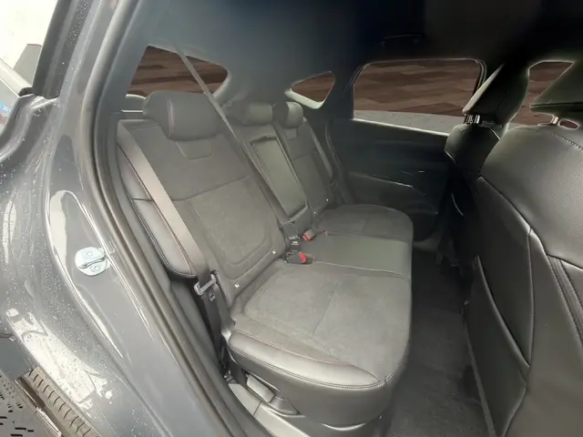 Vue intérieure côté gauche des sièges arrière gris foncé en tissu et cuir du Hyundai Tucson 1.6 Hybrid 2026 avec ceintures et appuie-têtes.
