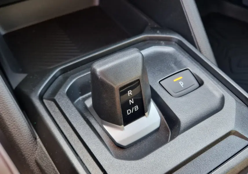 Gros plan sur le sélecteur de boîte automatique noir et gris du Dacia Duster 1.8 Hybrid 155, avec bouton de parking éclairé.