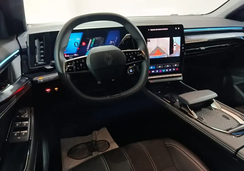 Vue intérieure avant du Renault Austral bleu 2024, volant cuir multifonctions et écran tactile central lumineux.