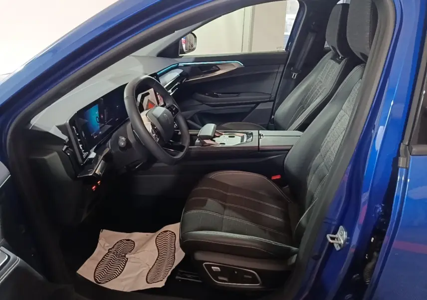 Intérieur côté conducteur du Renault Austral bleu 2024, montrant siège cuir, volant multifonctions et tableau de bord numérique.