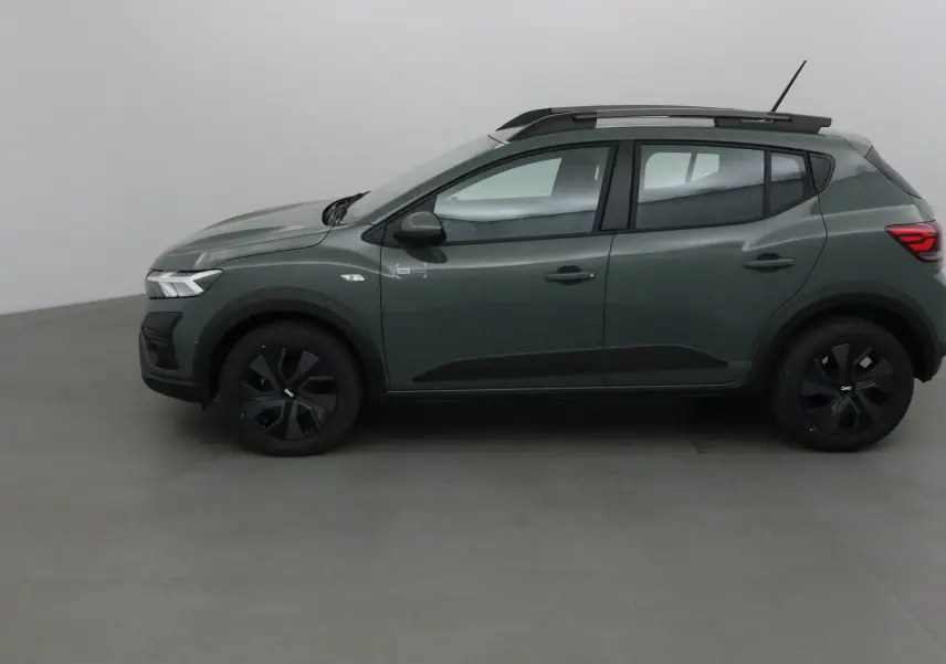 Profil côté gauche d'une Dacia Sandero Stepway 2025 en kaki Kichen avec barres de toit et jantes noires.