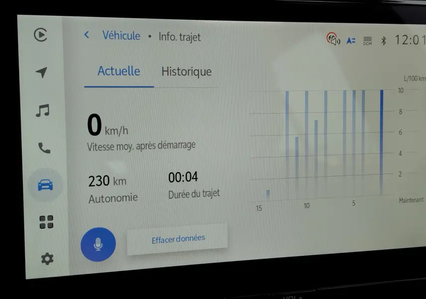 Écran tactile du tableau de bord du Toyota Corolla Cross gris acier 2025 affichant les données de trajet et autonomie hybride.