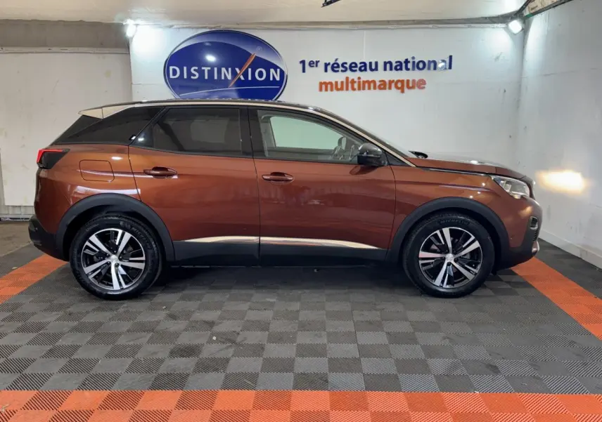 Peugeot 3008 orange vue de profil côté gauche, avec jantes alliage et toit noir contrasté dans un showroom.