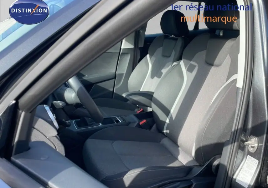 Vue intérieure côté conducteur de l'Audi Q2 30 TDI S-Line 2025, montrant les sièges tissu gris et la console centrale.