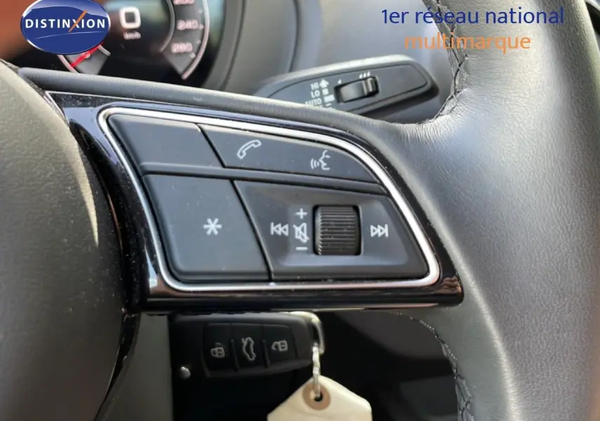 Gros plan sur les commandes du volant en cuir noir de l'Audi Q2 gris Manhattan 30 TDI S-Line 2025.