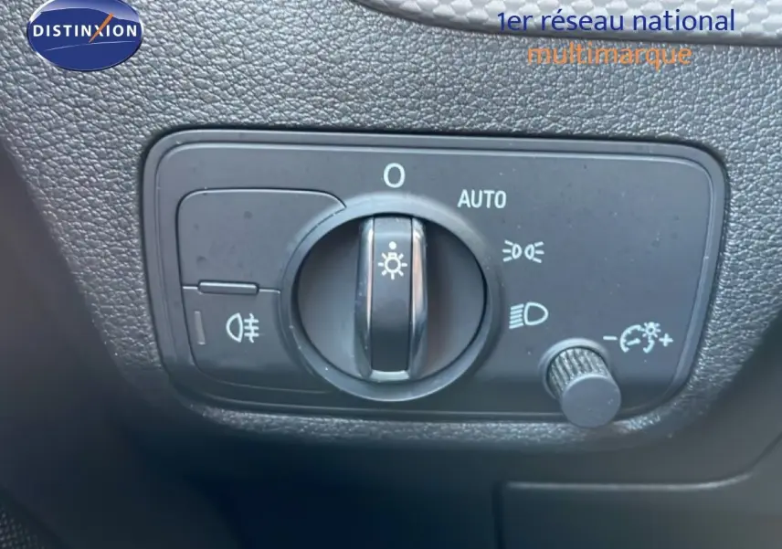 Gros plan sur le bouton de commande des phares dans l’habitacle de l’Audi Q2 gris Manhattan 30 TDI S-Line 2025.