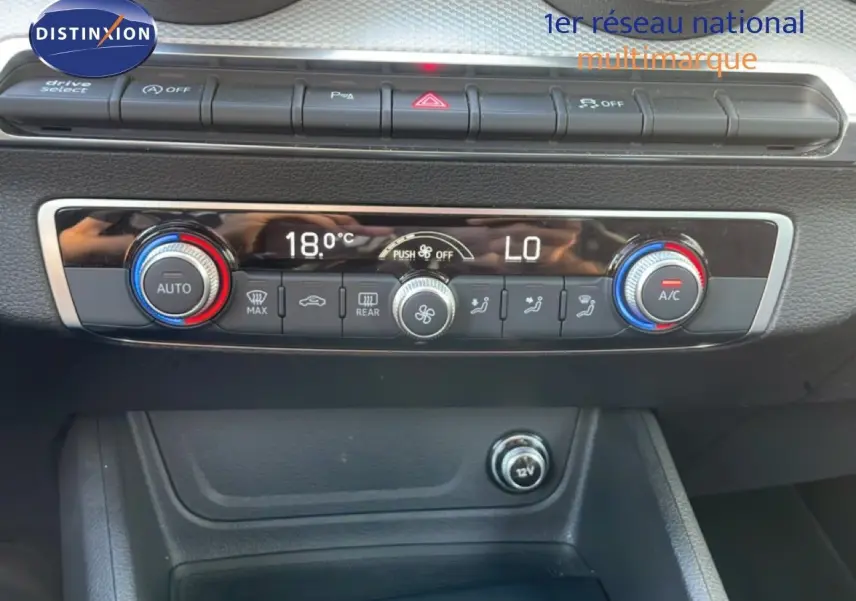Vue rapprochée de la console centrale de l’Audi Q2 30 TDI S-Line 2025, montrant les commandes de climatisation digitale.