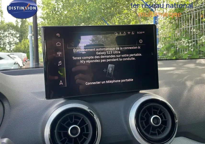 Vue intérieure centrée sur l’écran tactile et les aérateurs ronds du tableau de bord d’un Audi Q2 30 TDI S-Line 2025.