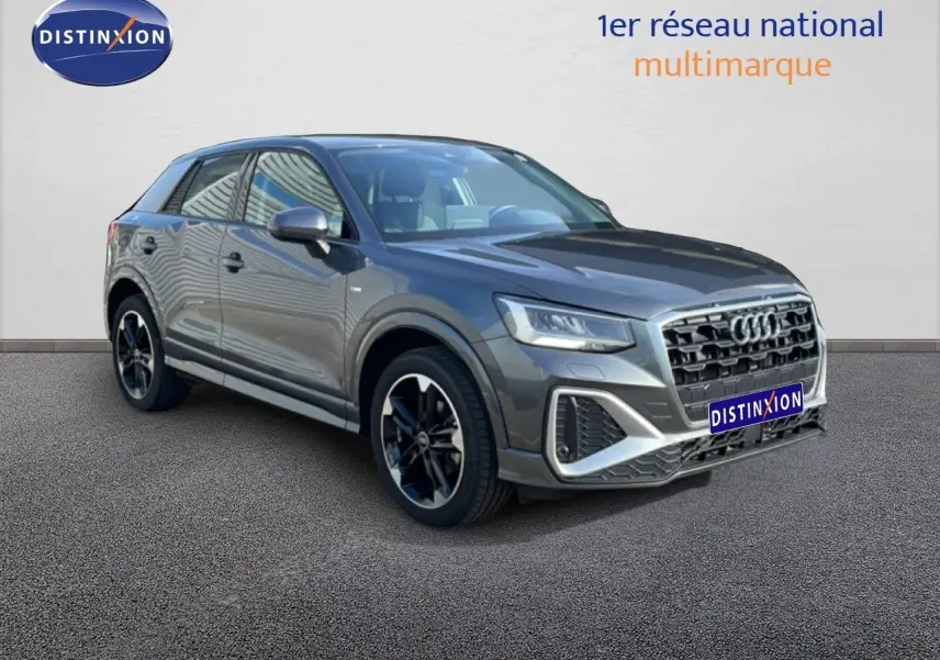 Audi Q2 30 TDI S-Line gris Manhattan métal en 3/4 avant droit, avec jantes noires et calandre distinctive.