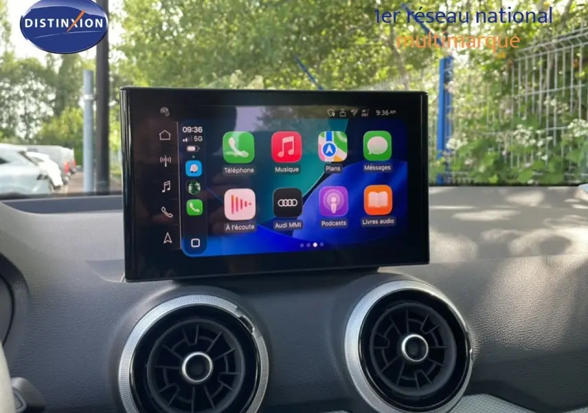 Vue rapprochée de l’écran tactile central et des aérateurs ronds du tableau de bord de l’Audi Q2 30 TDI gris Manhattan.