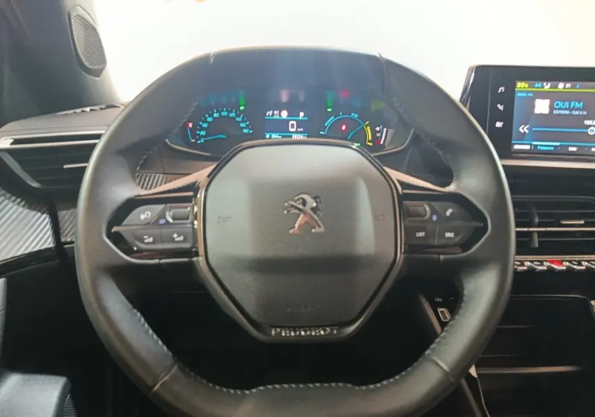 Vue intérieure centrée sur le volant cuir multifonctions et le combiné numérique du Peugeot E-2008 électrique 2023.