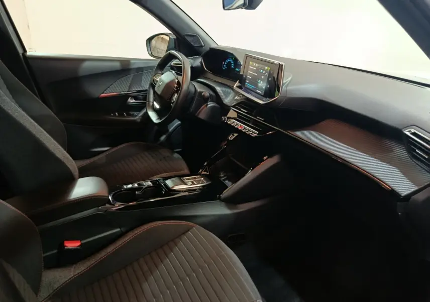 Intérieur côté conducteur du Peugeot E-2008 électrique gris clair 2023, avec tableau de bord digital et écran tactile central.