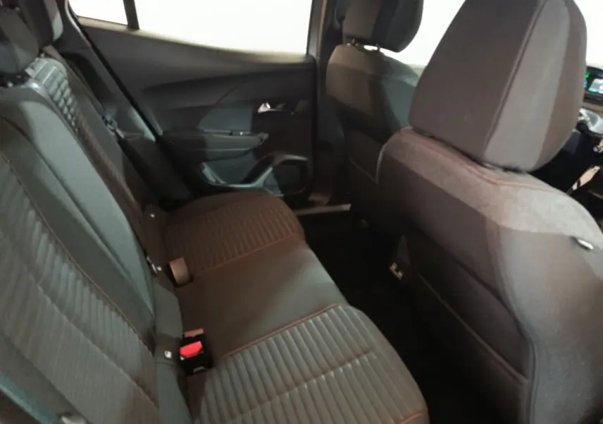 Vue intérieure côté gauche sur la banquette arrière noire avec surpiqûres rouges du Peugeot E-2008 électrique 2023.