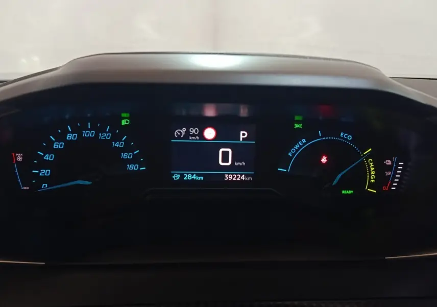 Gros plan sur le combiné d'instruments numérique du Peugeot E-2008 électrique, affichage vitesse et autonomie.