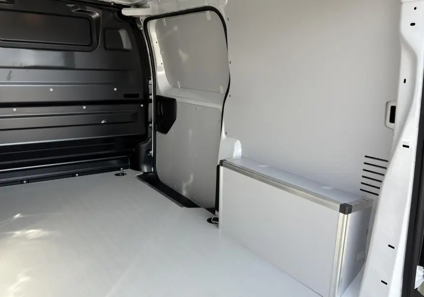 Intérieur du coffre du fourgon blanc Opel Vivaro 2024, plancher et habillages latéraux en bois avec coffrage aluminium.