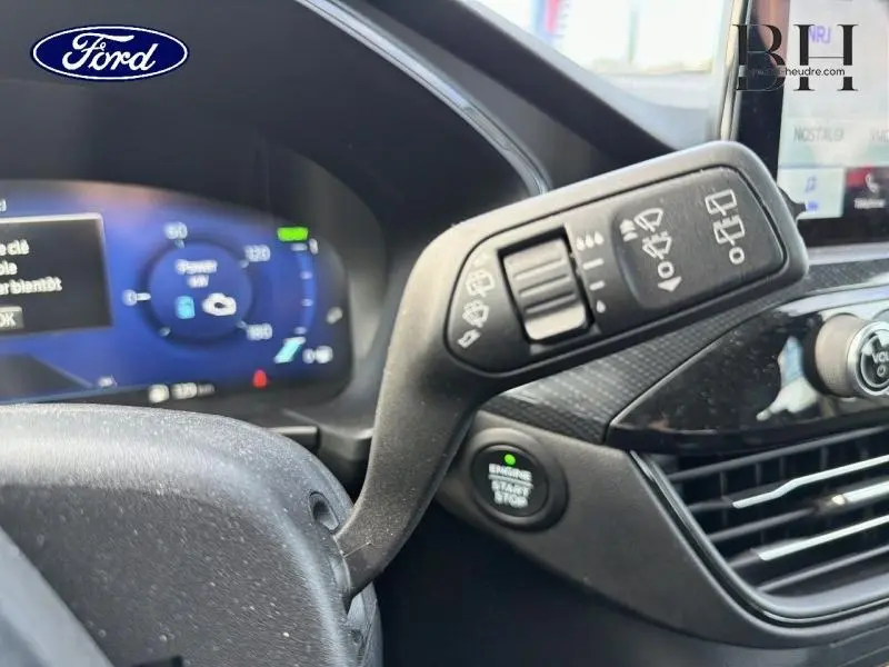 Gros plan sur la commande des essuie-glaces à gauche du volant dans l’habitacle du Ford Kuga gris métallisé.