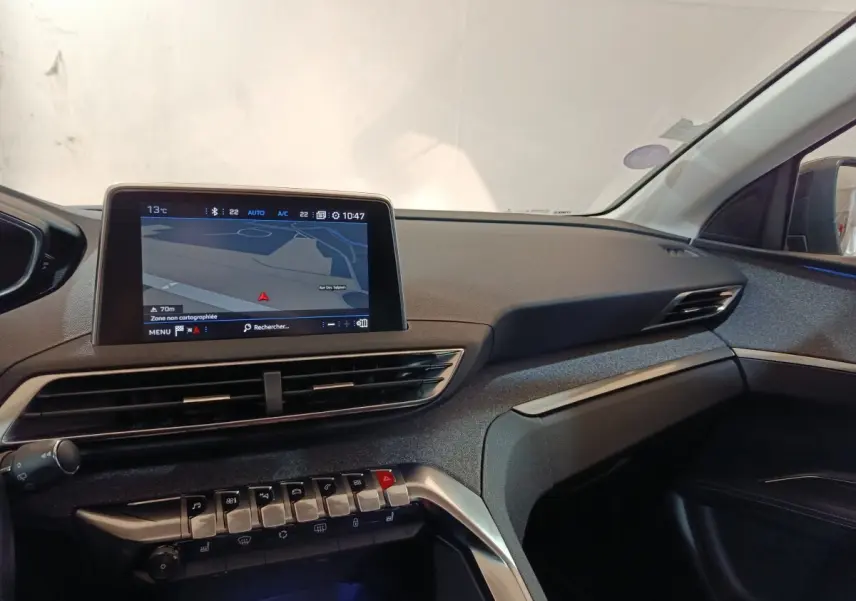 Vue intérieure côté passager du tableau de bord du Peugeot 3008 blanc, avec écran tactile de navigation allumé.
