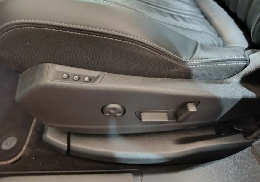 Gros plan sur les commandes de réglage électrique du siège avant noir du Peugeot 3008 blanc, version Allure 2019.